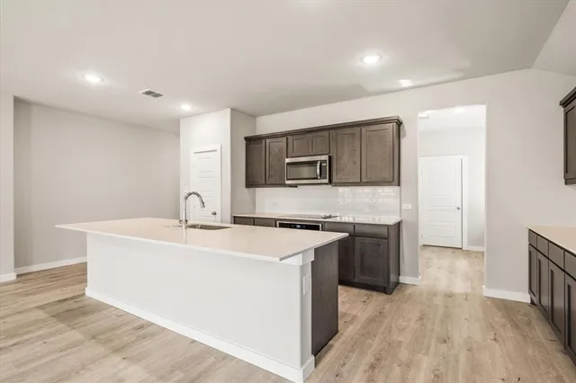 a kitchen with stainless steel appliances granite countertop a sink stove and refrigerator