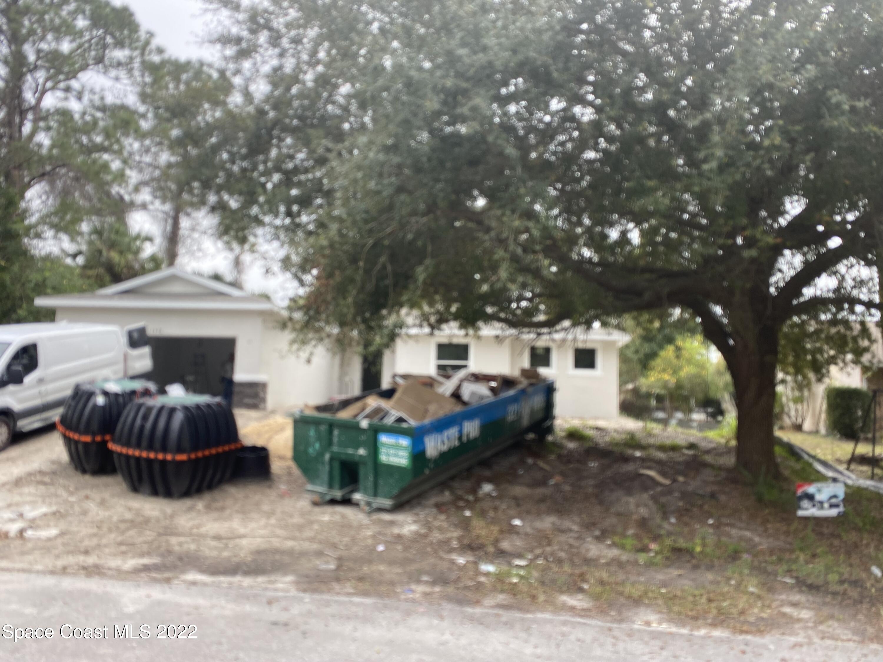 1376 Wing Road Southwest Palm Bay, FL 32908 - Photo 17 of 17 a front view of a house with sitting area and trees
