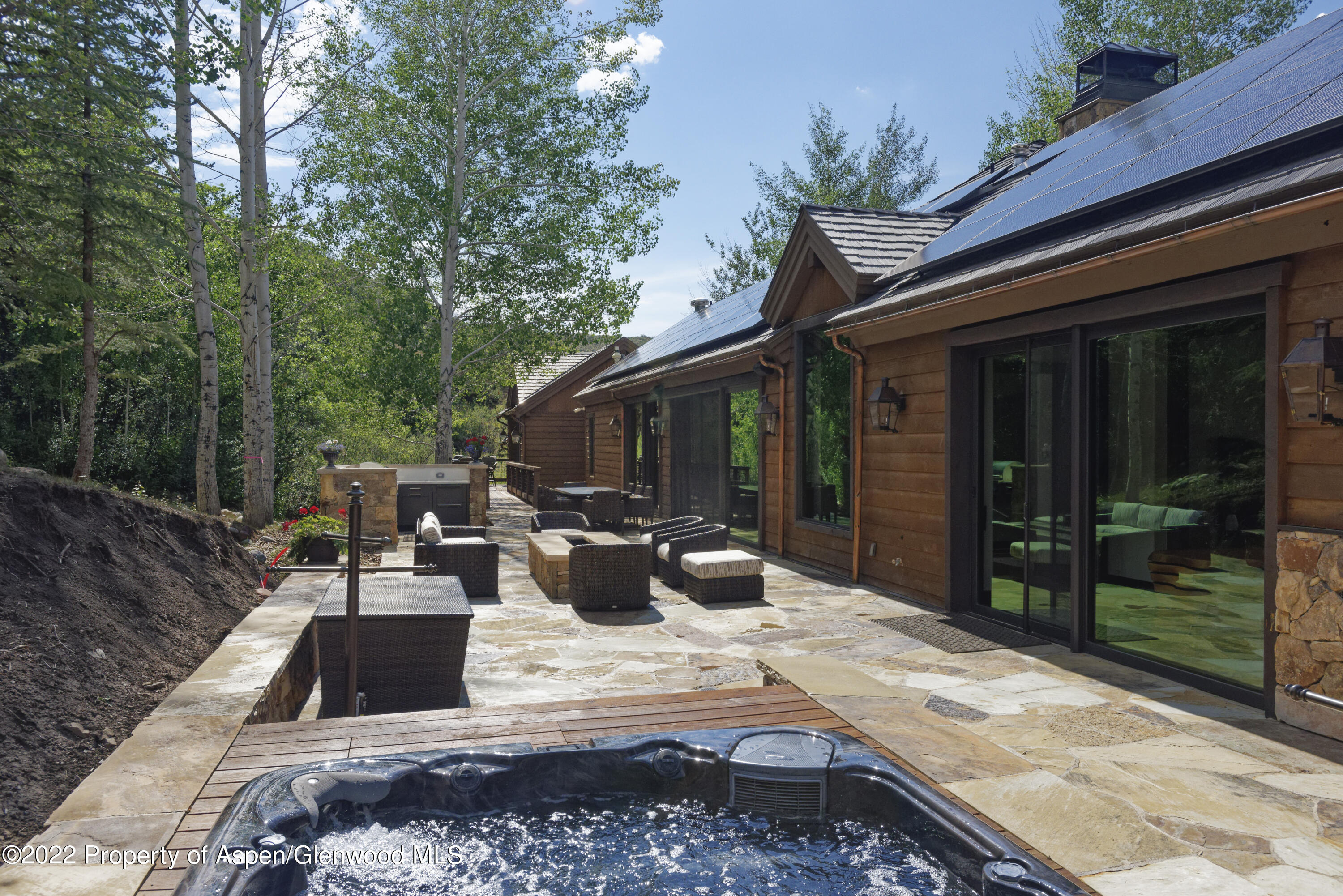 2322 Lazy O Road Snowmass, CO 81654 - Photo 35 of 42 a view of a patio with table and chairs potted plants and floor to ceiling window