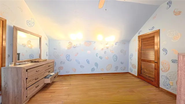 a view of a hallway with wooden floor and closet area