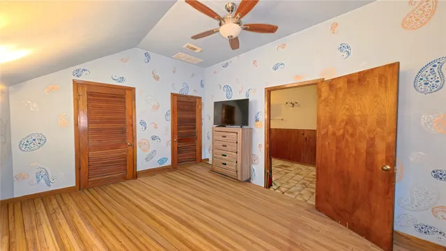 a view of an empty room with kitchen and a window