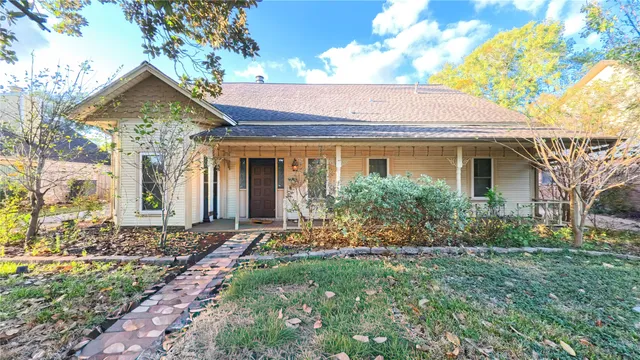 a view of a house with brick walls and a small yard