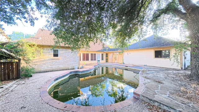a view of house with swimming pool outdoor seating