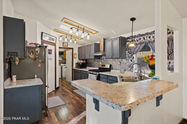 a kitchen with stainless steel appliances granite countertop a sink refrigerator and cabinets