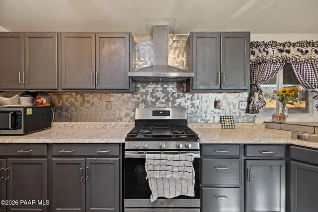 a kitchen with stainless steel appliances granite countertop a sink stove and cabinets