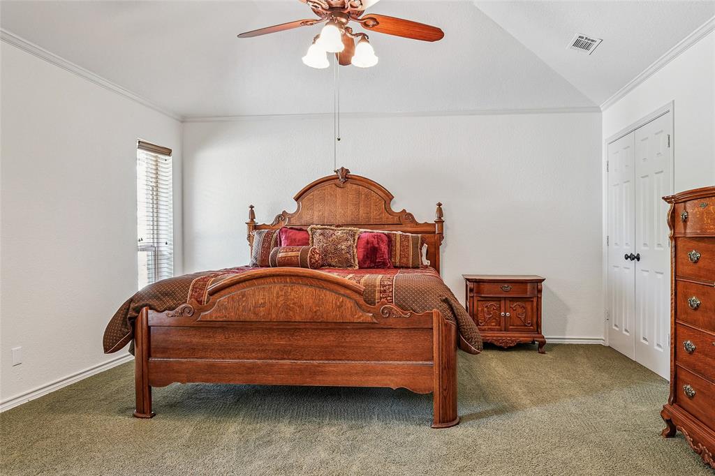 1006 Cochran Road Argyle, TX 76226 - Photo 15 of 40 a bedroom with a bed and a chandelier