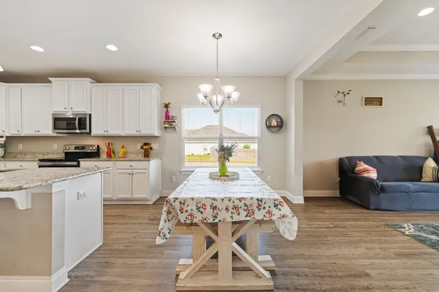 a living room with kitchen island furniture and a chandelier