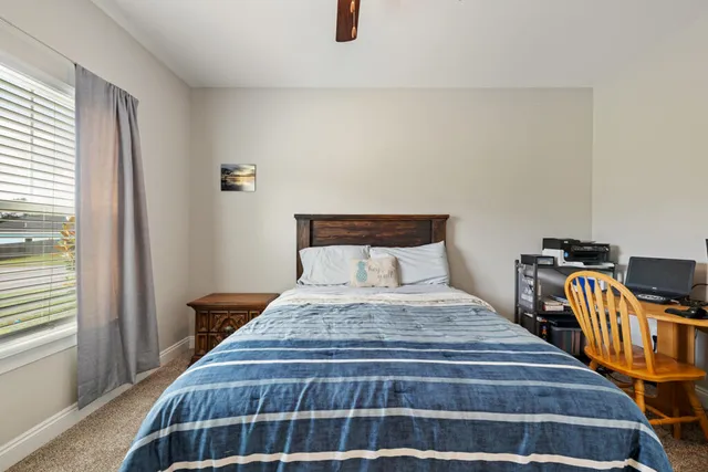 a bedroom with bed and wooden floor
