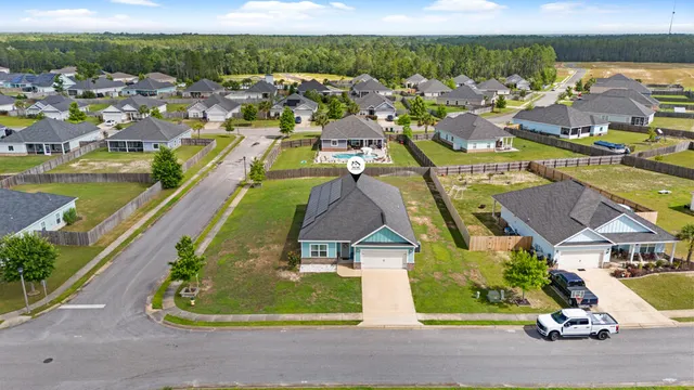 an aerial view of residential houses with outdoor space and parking