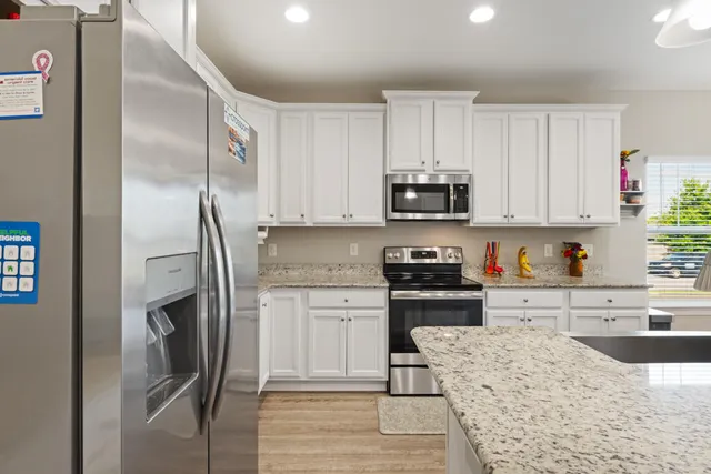 a kitchen with stainless steel appliances granite countertop a refrigerator sink and stove