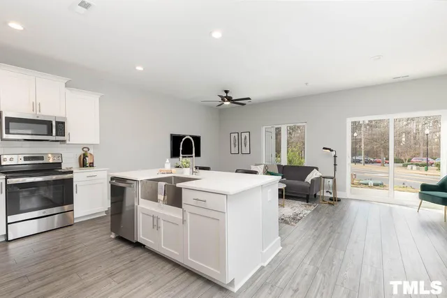 a open kitchen with a stove a sink dishwasher and a microwave oven with wooden floor