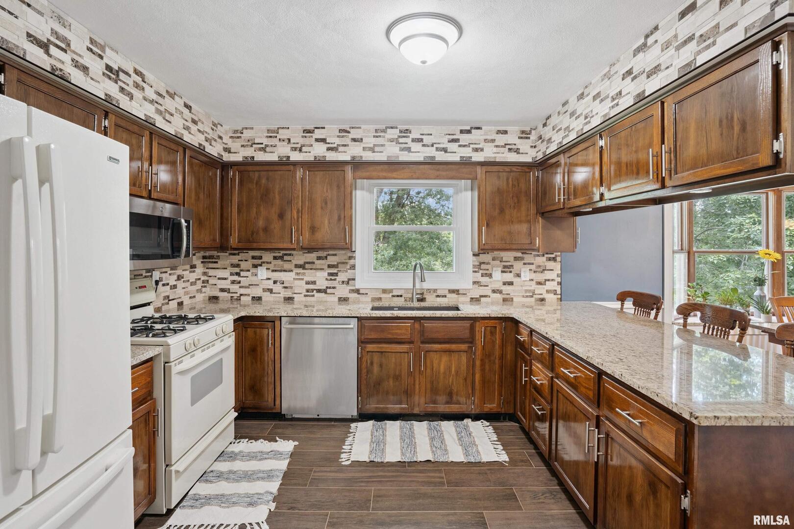8528 101st Street West Andalusia, IL 61232 - Photo 12 of 42 a kitchen with stainless steel appliances granite countertop a sink stove and refrigerator