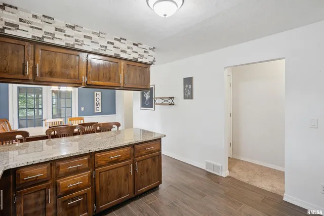 a room with granite countertop a sink and a wooden floor