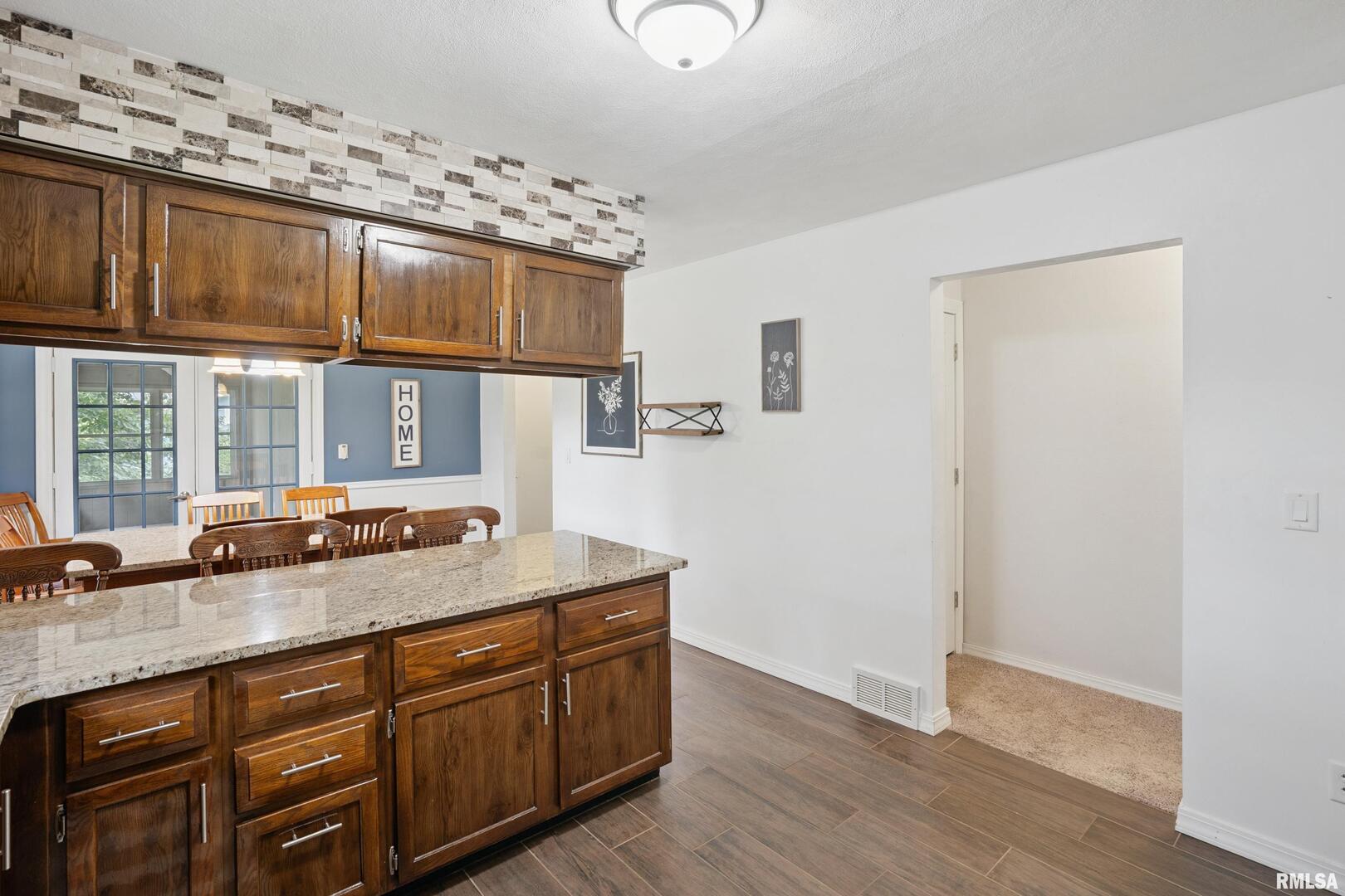 8528 101st Street West Andalusia, IL 61232 - Photo 13 of 42 a room with granite countertop a sink and a wooden floor