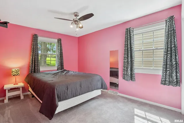 a bedroom with a bed chandelier and a window