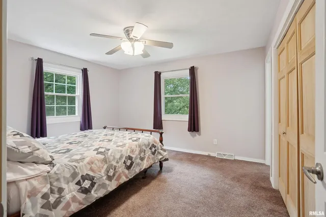 a bedroom with a bed and a large window