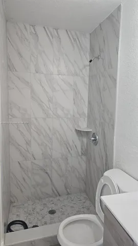 a bathroom with a toilet and a shower