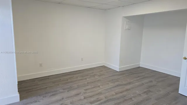 a view of an empty room with wooden floor