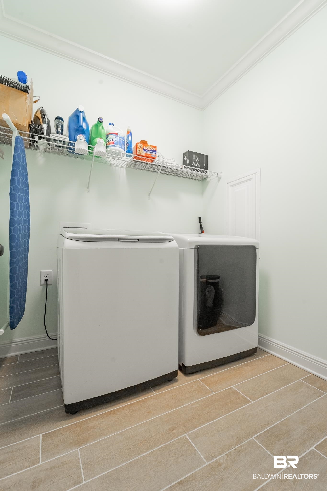 10975 Legacy Lane Mobile, AL 36608 - Photo 34 of 40 Clothes washing area with washing machine and clothes dryer, crown molding, and hardwood / wood-style floors