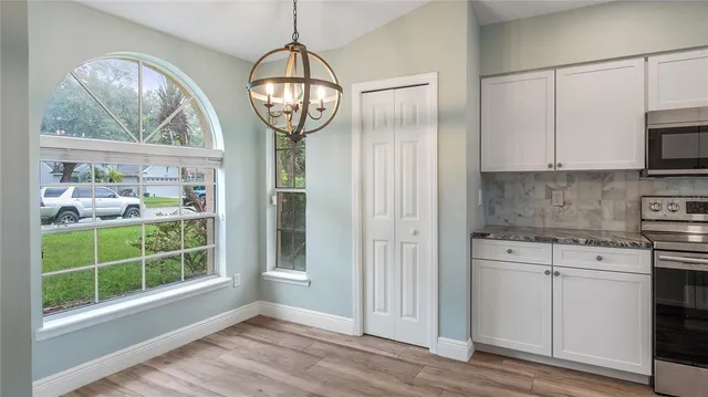 a view of a kitchen with wooden floor and a window