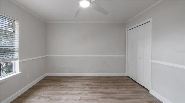 a view of a small space with wooden floor and a window