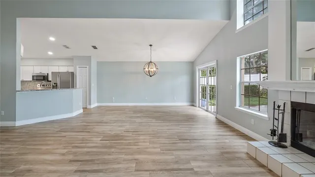 a view of an empty room with a fireplace and a window