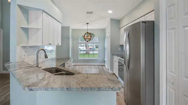 a kitchen with stainless steel appliances granite countertop a refrigerator and a sink