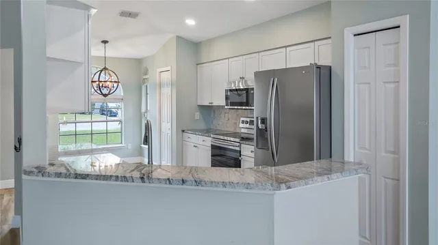 a kitchen with granite countertop a refrigerator and a sink