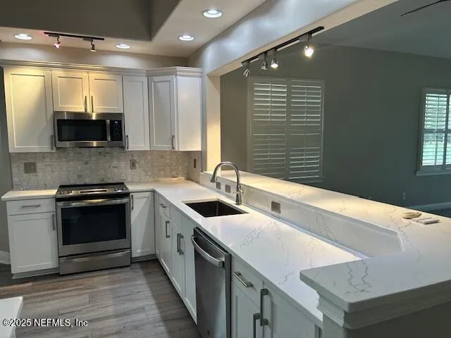 a kitchen with granite countertop a sink and a stove top oven