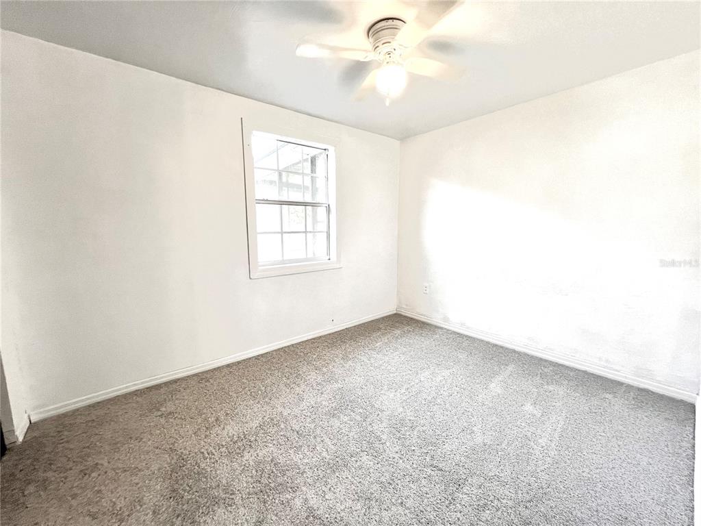 925 Lake Avenue Edgewater, FL 32132 - Photo 6 of 18 an empty room with windows and fan