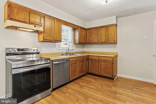 a kitchen with a sink stove top oven and cabinets