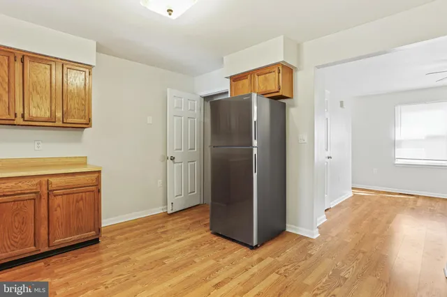 a view of a kitchen with wooden cabinet and refrigerator