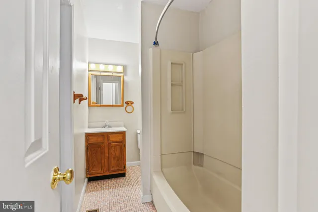 a bathroom with a tub sink and mirror