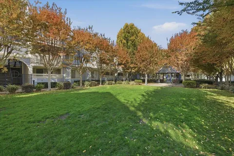 a front view of a house with a garden and trees