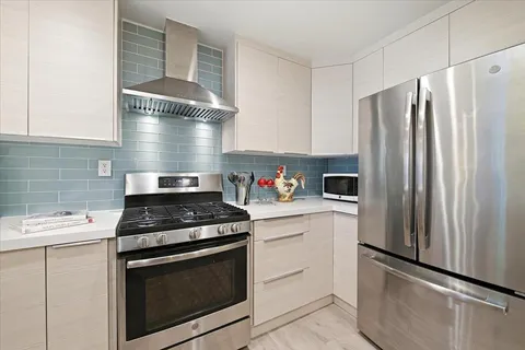 a kitchen with stainless steel appliances white cabinets and a stove