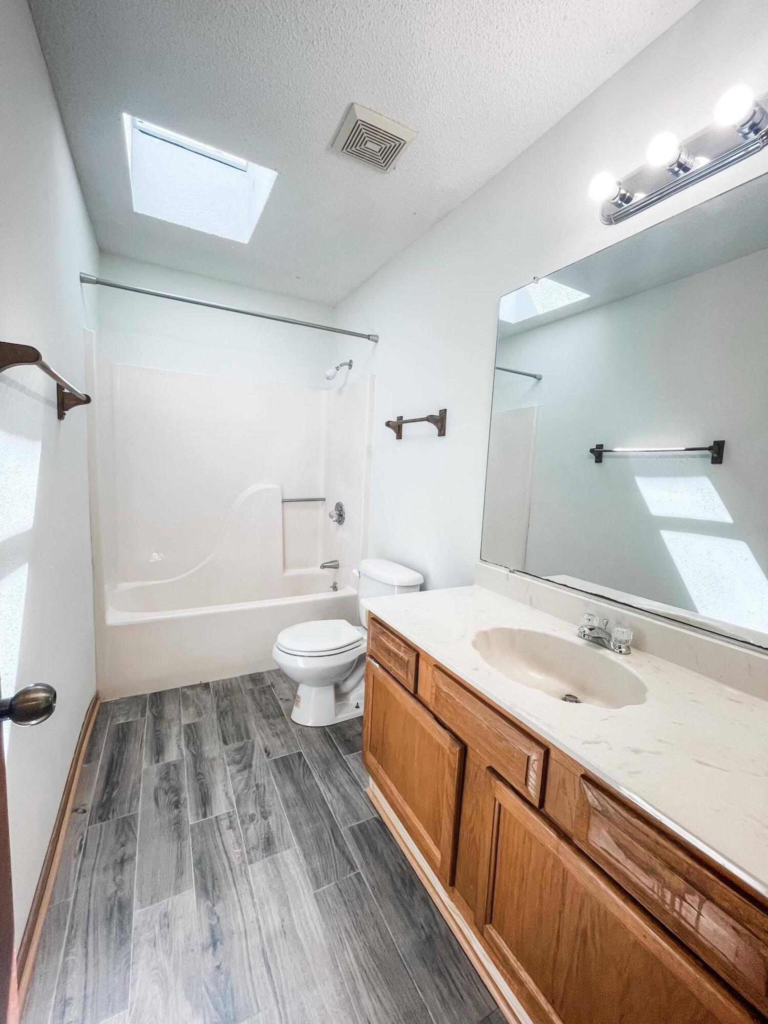 888 Culp Avenue, Unit 3 Fort Walton Beach, FL 32547 - Photo 11 of 12 a spacious bathroom with a sink a toilet a shower and a mirror