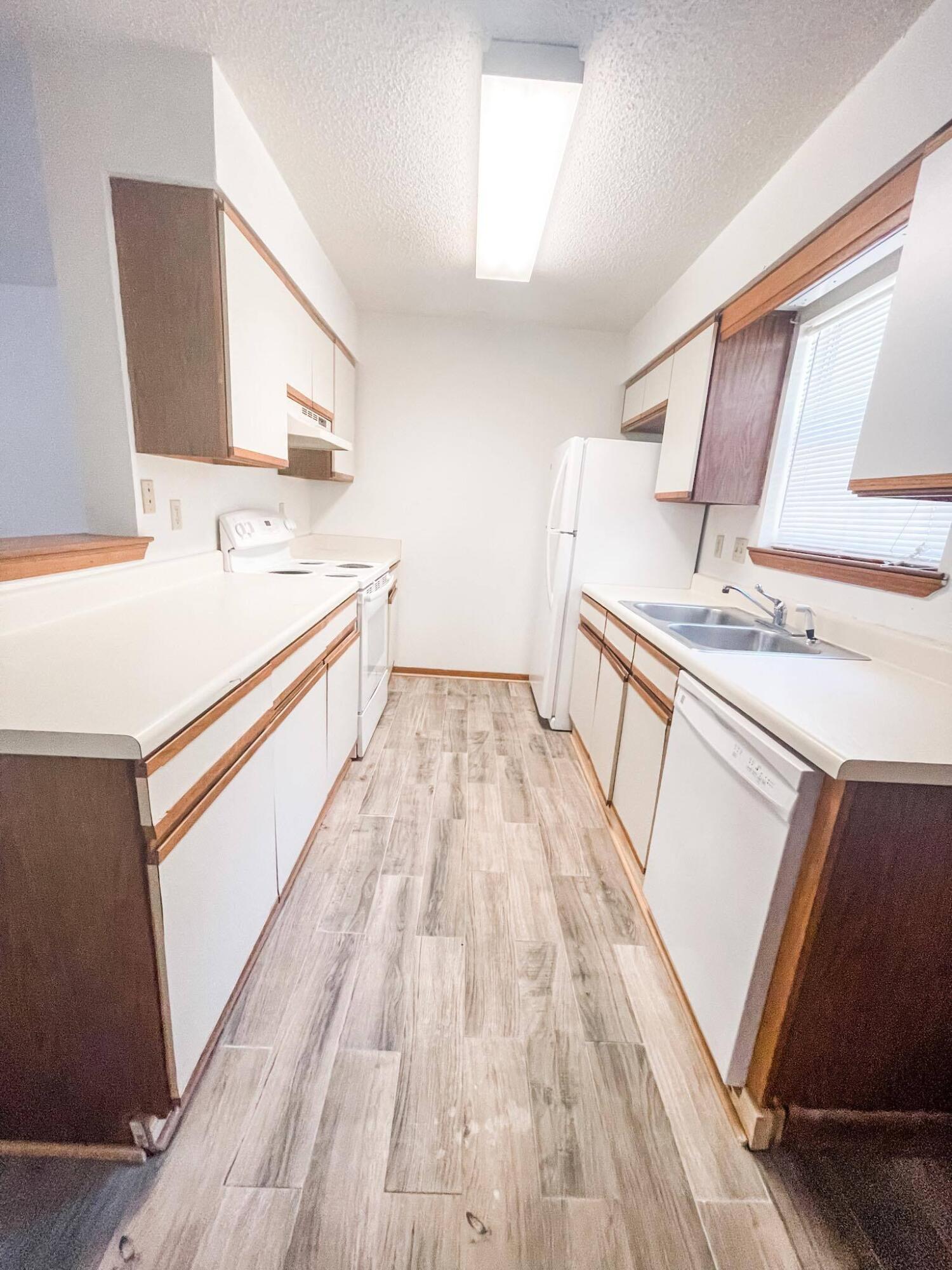 888 Culp Avenue, Unit 3 Fort Walton Beach, FL 32547 - Photo 6 of 12 a view of a kitchen with a sink and wooden floor