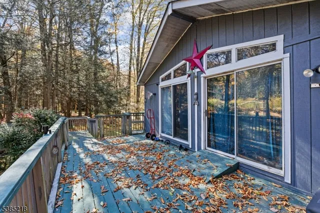 a balcony with wooden floor stairs and wooden fence
