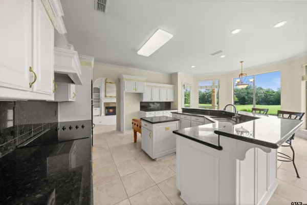 a view of an empty room with windows and a chandelier