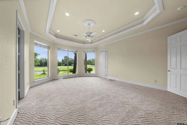 an empty room with windows and ceiling fan