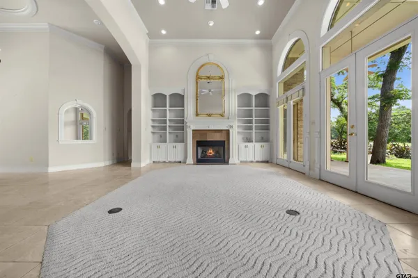 a view of an empty room with a window and kitchen view
