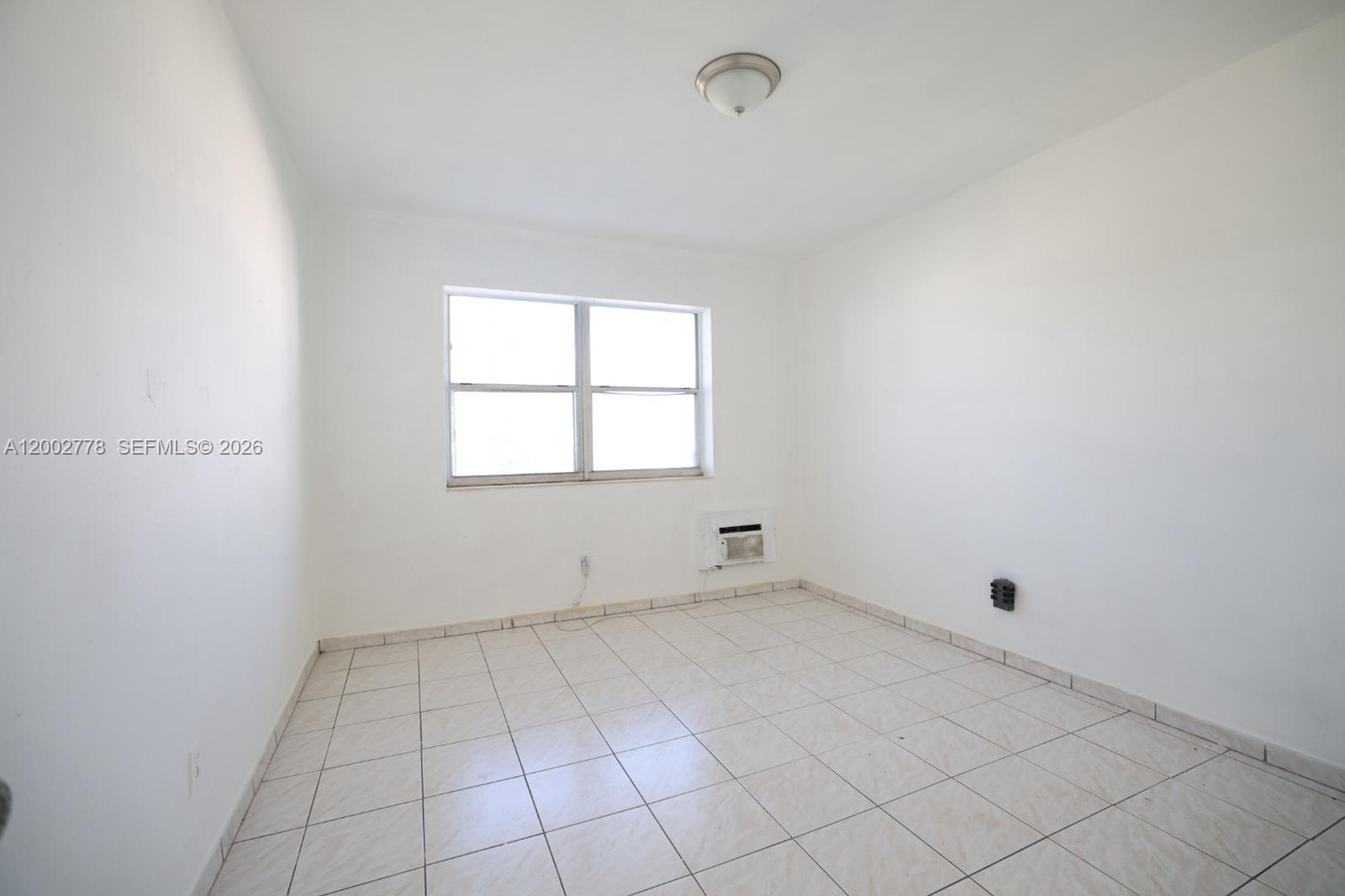 770 83rd Street, Unit 3 Miami Beach, FL 33141 - Photo 4 of 7 an empty room with white walls and tiles