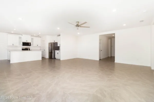 an empty room with window and ceiling fan