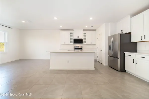 an empty room with a ceiling fan and a window