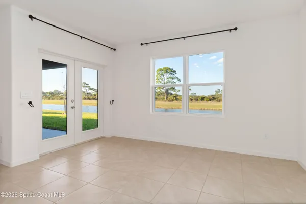 an empty room with a window and a ceiling fan
