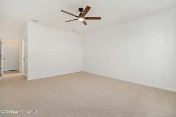 an empty room with a ceiling fan and a window