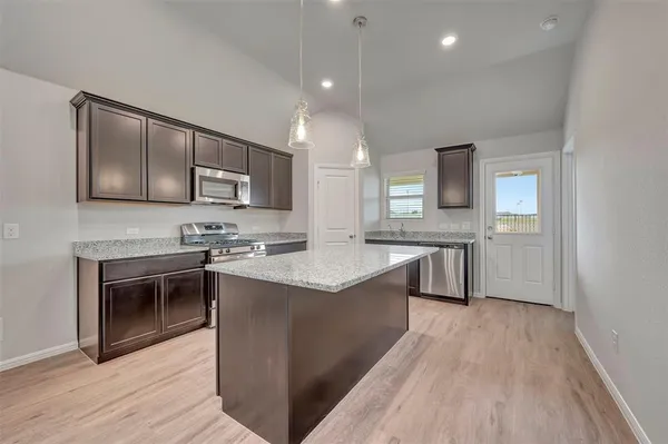 a kitchen with stainless steel appliances granite countertop a sink stove and refrigerator
