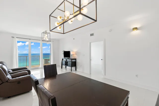 a living room with furniture a flat screen tv and a large window