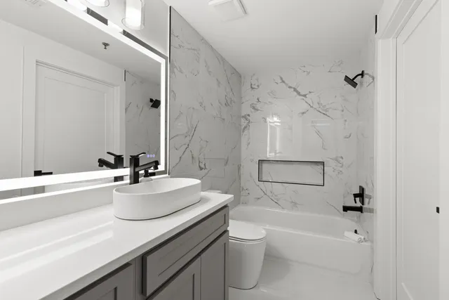 a bathroom with a sink a toilet and shower