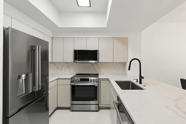 a kitchen with stainless steel appliances a stove a sink and a refrigerator